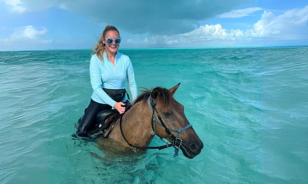 Rider on horseback in turquoise waters