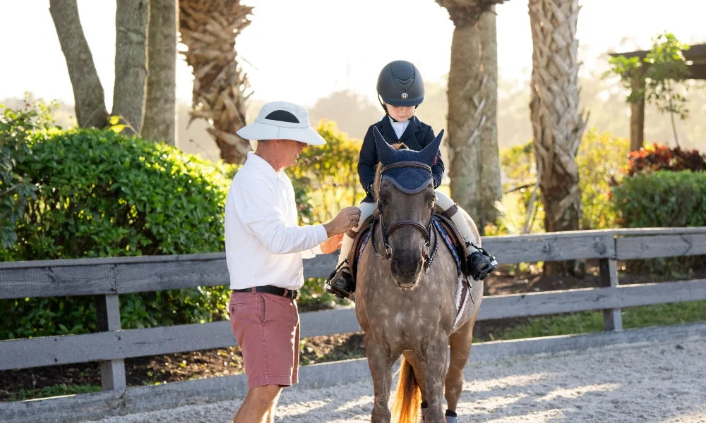 Instructor helping a young rider on horseback