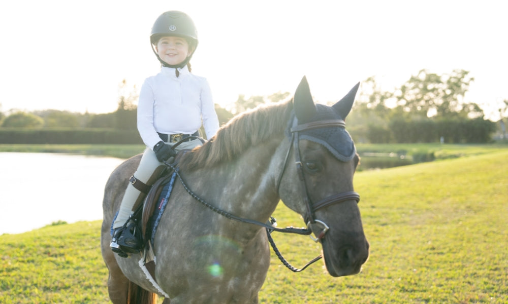 girl in show clothing on horseback
