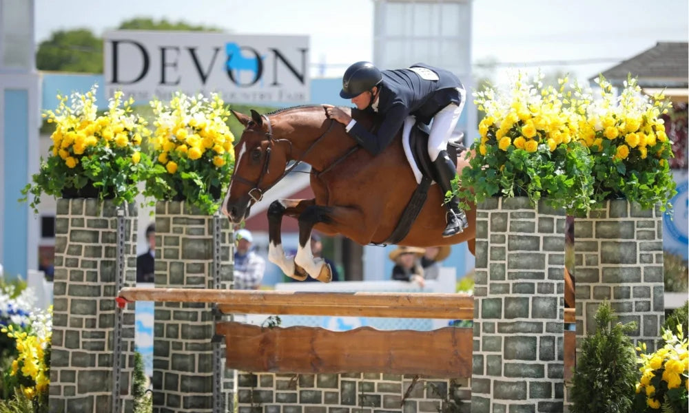 A horse and rider taking on a jump at the Devon Horse Show